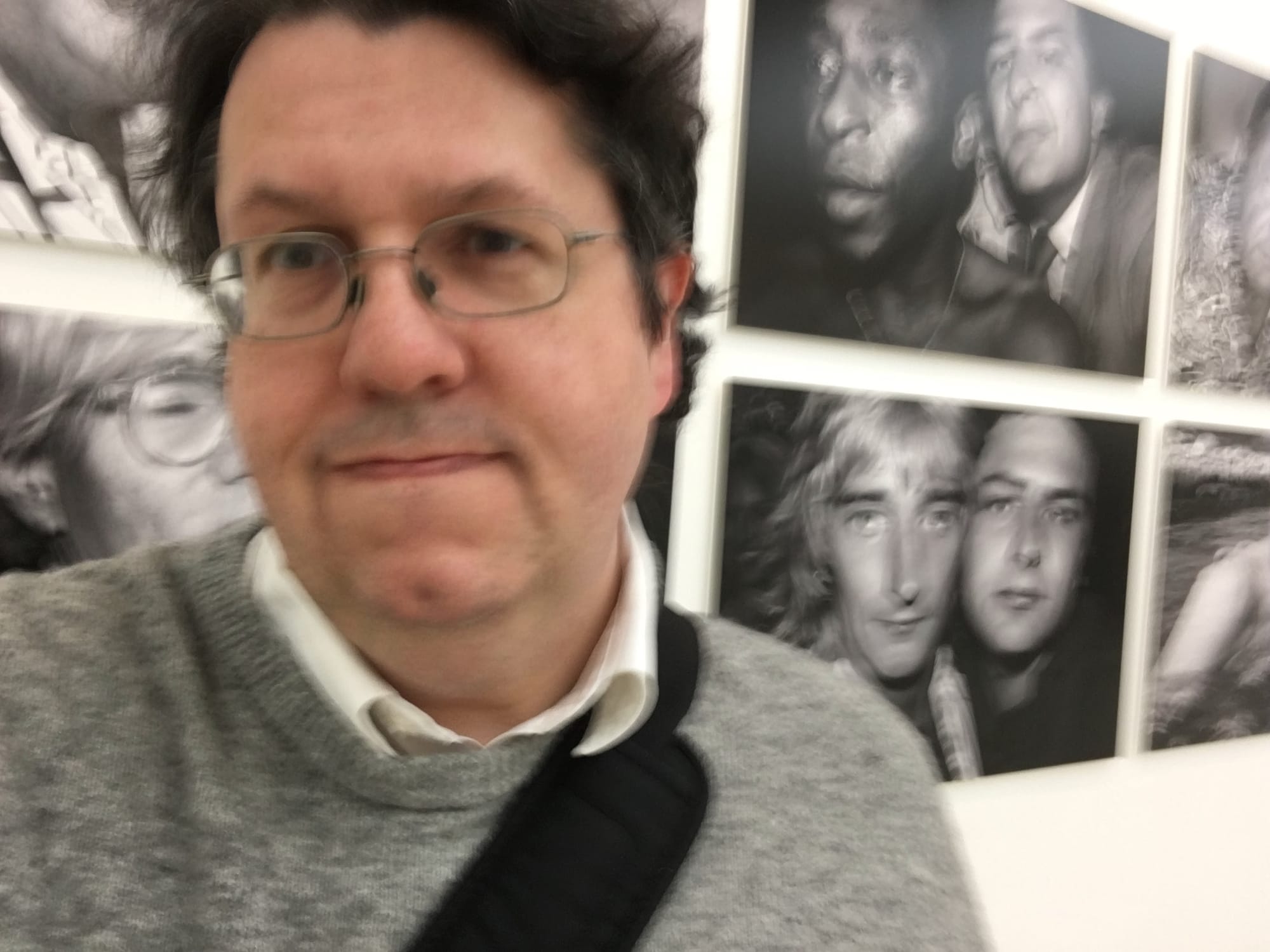 Ian Betteridge in a grey sweater in front of a picture of Rod Stewart, for reasons only he will know. 